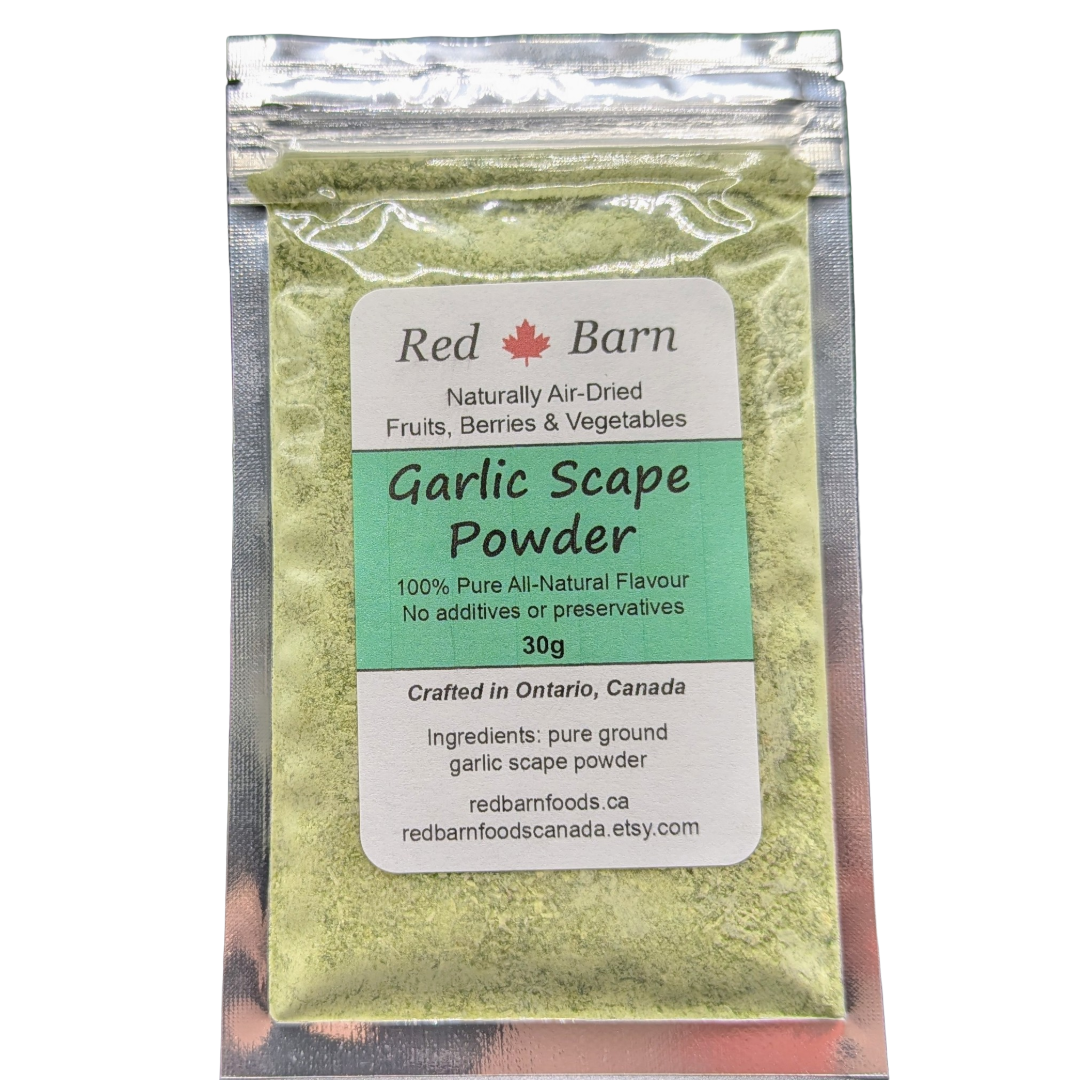 A 30g pouch of Red Barn Garlic Scape Powder, containing light green dried garlic scapes, in a clear resealable stand-up bag with a white and green label.